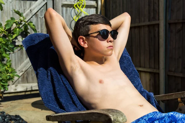 白人少年男孩在花园里晒太阳戴墨镜 — 图库照片