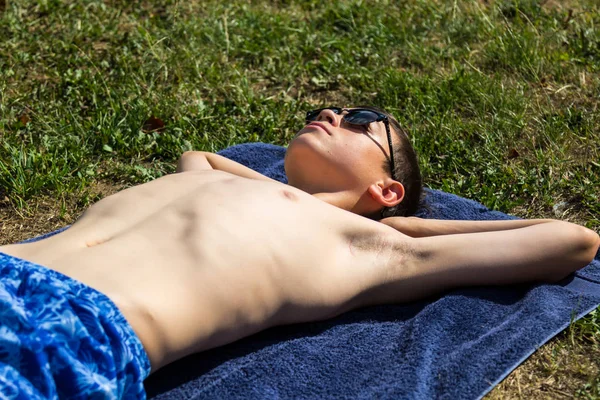 Beyaz Genç Çocuk Güneş Gözlüğü Takıyor Bir Bahçede Güneşlenme — Stok fotoğraf