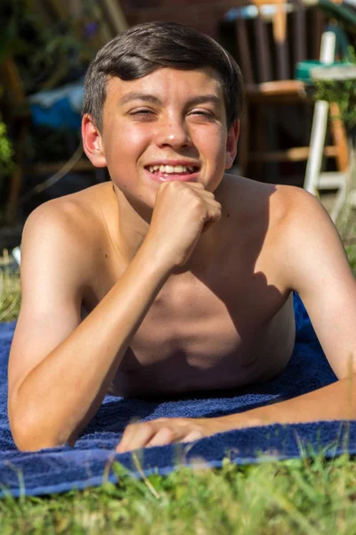 白人少年男孩在花园里晒日光浴 — 图库照片