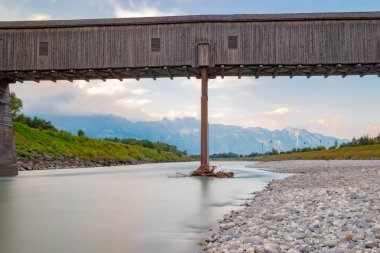 The old wooden bridge across the river Rhine on the border of Liechtenstein and Switzerland clipart