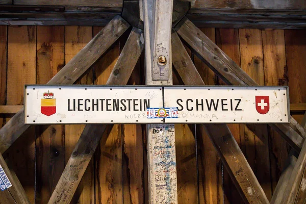 The international border post on the old wooden brdge across the river Rhine between Liechtenstein and Swizterland