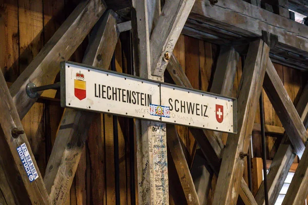 The international border post on the old wooden brdge across the river Rhine between Liechtenstein and Swizterland