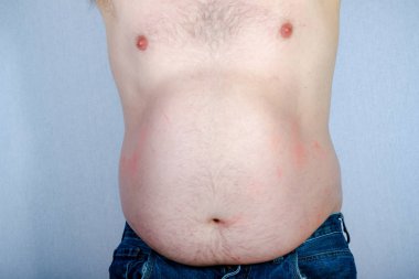 Ön taraftan görüntülenen ayakta gömleksiz beyaz adam kilolu