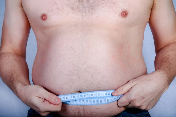 太りすぎの上半身裸の白人男を彼の胃を測定 — ストック写真