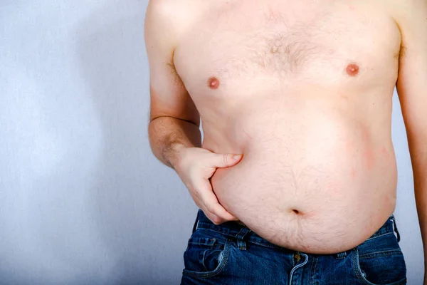 Kilolu gömleksiz beyaz adam onun karın yağ holding