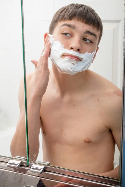 Хлопчик-підліток голиться вранці — стокове фото