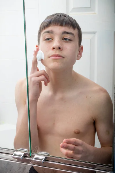 Хлопчик-підліток голиться вранці — стокове фото