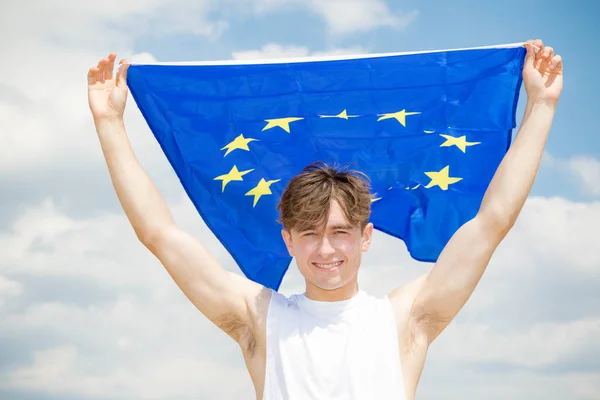 Kaukasiska hane på en strand som innehar en EU-flagga — Stockfoto