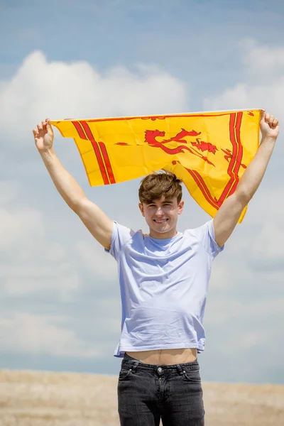 Caucasian male on a beach holding a Lion Rampant of Scotland fla — Stock Photo, Image