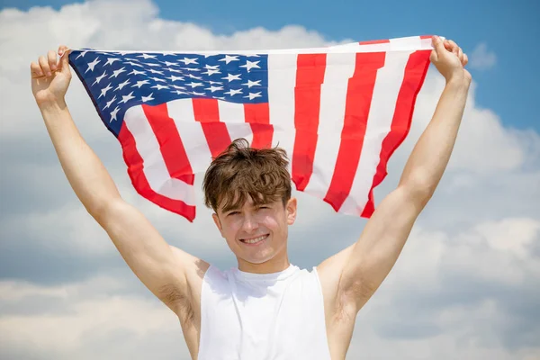 Kavkazský samec na pláži, držící americkou vlajku — Stock fotografie