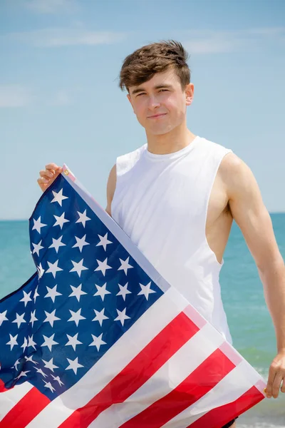 미국 국기를 들고 해변에서 백인 남성 — 스톡 사진
