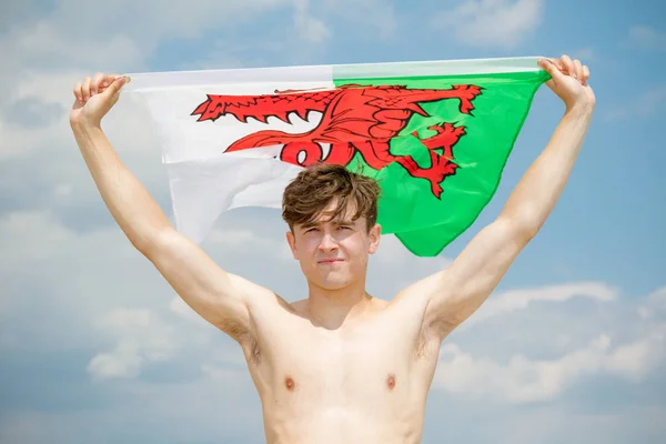 Maschio caucasico su una spiaggia con una bandiera gallese — Foto Stock