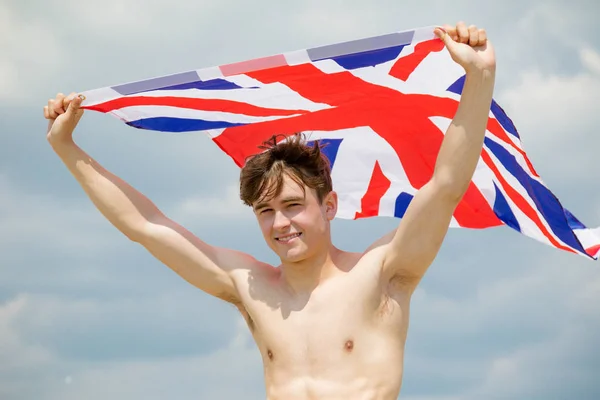 Blanc mâle sur une plage tenant un drapeau britannique — Photo