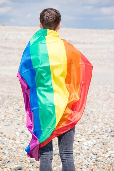 Maschio caucasico su una spiaggia con una bandiera Pride — Foto Stock