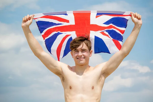 Maschio caucasico su una spiaggia con una bandiera britannica — Foto Stock
