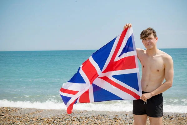 Kaukasischer Mann am Strand mit britischer Flagge — Stockfoto