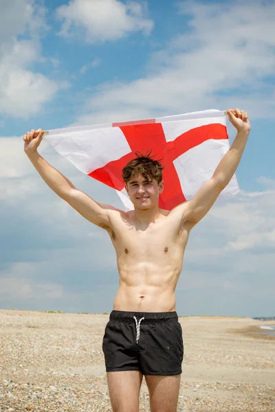 Kaukasischer Mann an einem Strand mit einer englischen Flagge — Stockfoto