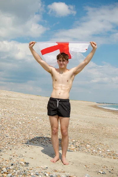 Kaukasischer Mann an einem Strand mit einer englischen Flagge — Stockfoto