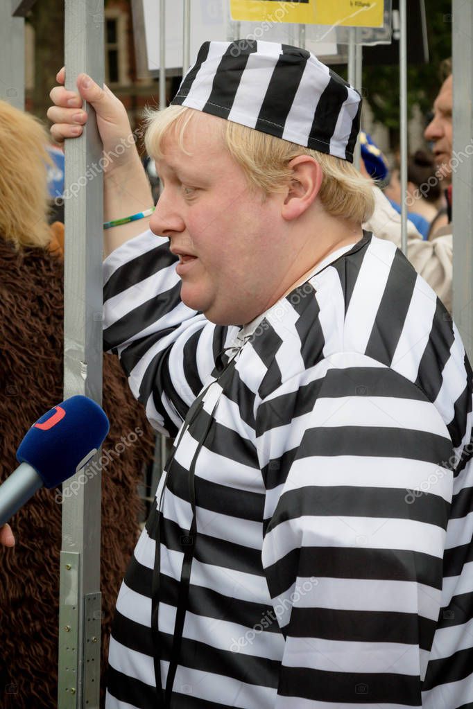 London, United Kingdom, June 4th 2019:- A Boris Johnson lookalike dressed in Prison Uniform in Parliament Square protesting against the up coming court case the leading candiate to replace the Prime Minister faces
