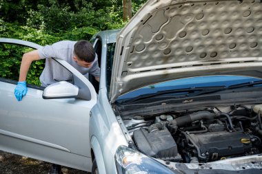 Bir araba üzerinde çalışan genç çocuk