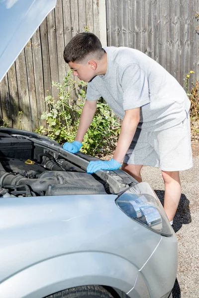 Tonårs pojke som arbetar på en bil — Stockfoto