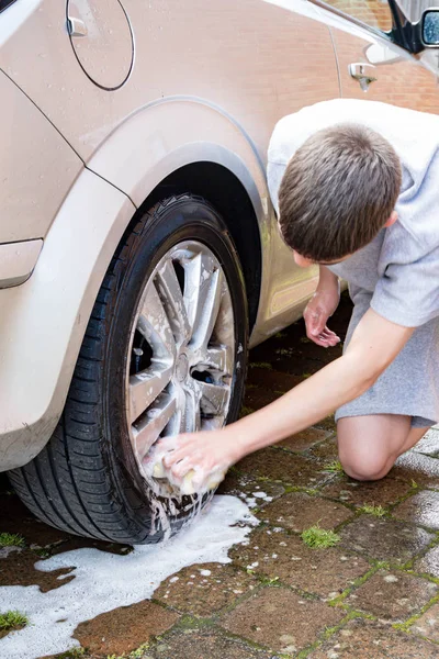 Adolescent garçon lavage un voiture — Photo