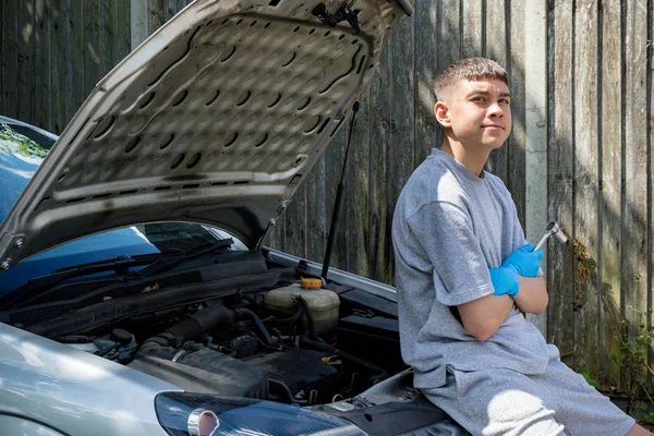 Adolescent garçon travaillant sur un voiture — Photo