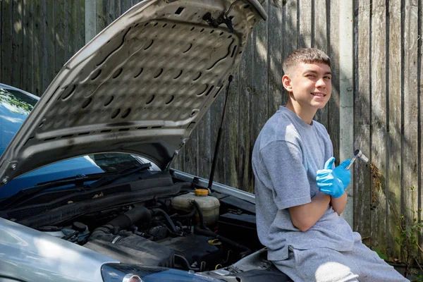 Adolescent garçon travaillant sur un voiture — Photo