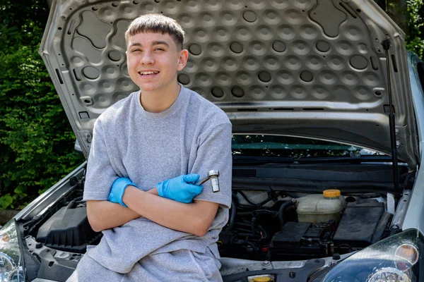 Adolescent garçon travaillant sur un voiture — Photo