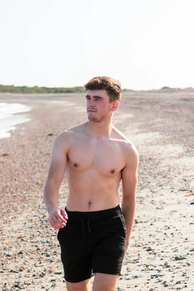 Shirtless på en strand — Stockfoto