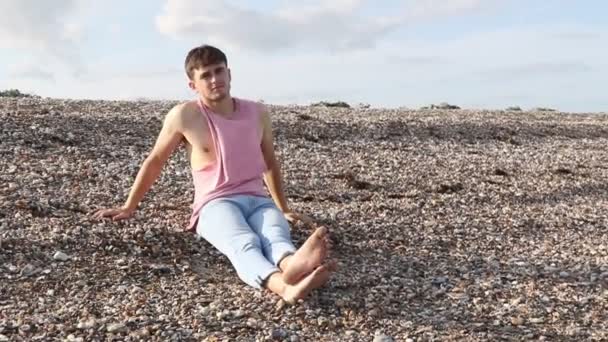 Junger Kaukasischer Erwachsener Mann Sitzt Einem Strand Und Zieht Sein — Stockvideo