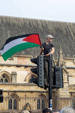 Londra, Birleşik Krallık, 6 Eylül 2025 - Parilament Meydanı 'ndaki Pro Filistin Protestocuları, genç bir protestocu Filistin bayrağıyla trafik ışığına tırmandı
