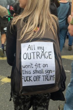 London, United Kingdom, September 17th 2025: The Stop Trump Coalition March in Central London. A Protester holds a sign reading all my outrage won't fit on theis small sign fuck off trump
