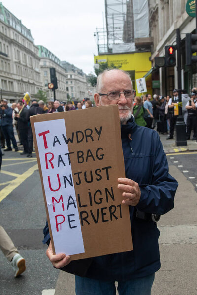 Лондон, Великобритания, 17 сентября 2025 года: Марш коалиции "Стоп Трампу" в центре Лондона. A Protester holds a sign reading tawdry, ratbag, unjust, malign, pervert