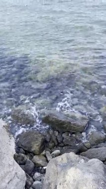 Deniz dalgaları sahil kayalıklarına vuruyor. Denizde kolay bir heyecan. Güzel deniz. Yüksek kalite 4k görüntü