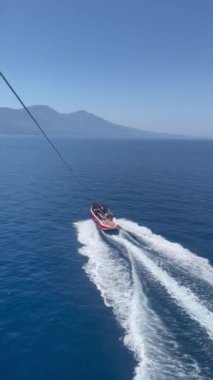 Denizin mavi sularını geçen bir teknenin havadan görüntüsü. Rotası boyunca denizde bir iz bırakır. Aqua Denizi 'nde hızlı hareket eden sürat teknesinin hava görüntüsü. Yüksek kalite 4K görüntü.