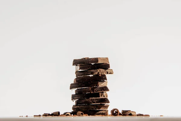 Beyaz arka planda birikmiş çikolata parçaları.