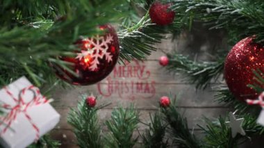 Mutlu noel arkaplanı, kamera hareketi, düşen kar, eski ahşap duvar, hediye süslemeleri ve yıldızlı karlı dallar.