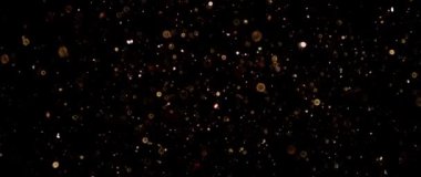 Güzel altın parıldayan parçacıklar, yavaş çekimde siyah zemin üzerinde parlayan mercekler..