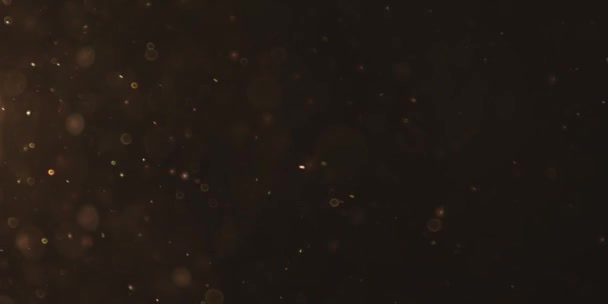 Belles particules dorées chatoyantes avec éclat de lentille sur fond noir au ralenti.