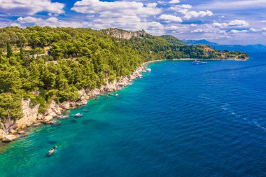 Marjan 'ın Split' teki güney kesiminin görüntülerinde Kasjuni Sahili turkuvaz Adriyatik suları, kayalık kıyı şeridi, yeşil çam ormanları ve manzaralı bir Akdeniz yaz manzarası görülüyor.