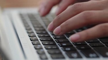 Kadın elleri ofisteki masada dizüstü bilgisayarda klavye kullanıyor. Kadın içerideki bilgisayarın tuşlarına basarak metin yazıyor. Uzak işyerindeki iletişim teknolojisi