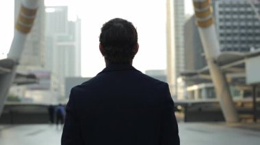 Siyah ceketli bir işadamı modern mimari arka görüşüyle cadde boyunca yürür. Başarılı şirket CEO 'su şehir merkezindeki Megapolis' te geziniyor. İş kariyeri gelişimi