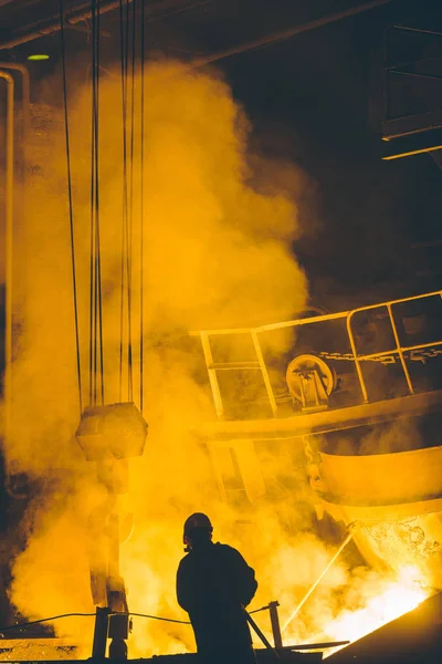 Worker controlling metal melting in furnaces