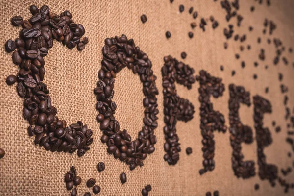 coffee word written with toasted coffee beans on top view composition