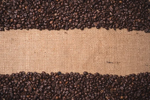 Top view toasted coffee beans frame on juta textile