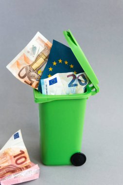 euro banknot çöp kutusu içinde Avrupa Birliği ülkelerinin bayrakları. kriz kavramı