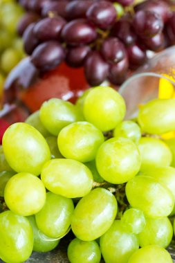 Demet taze farklı olgun üzüm ve bir şişe kırmızı şarap bir mavi ahşap dokusal yüzeyinde. metin reklam alanı 