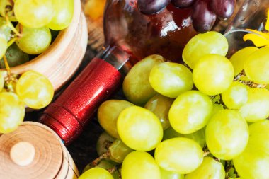 Demet taze farklı olgun üzüm ve bir şişe kırmızı şarap bir mavi ahşap dokusal yüzeyinde. metin reklam alanı 