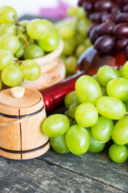 Demet taze farklı olgun üzüm ve bir şişe kırmızı şarap bir mavi ahşap dokusal yüzeyinde. metin reklam alanı 